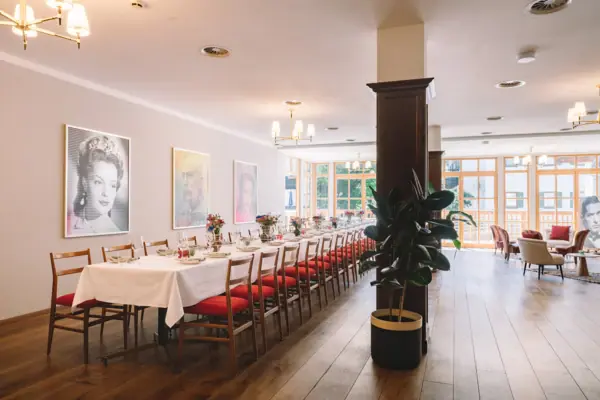 A long table with chairs and a plant in front of it.