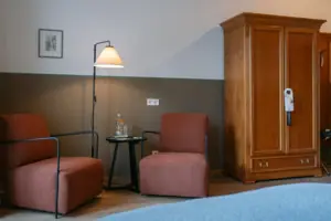A room with a bed and some chairs.