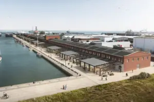 A dock with a building and a body of water outside.