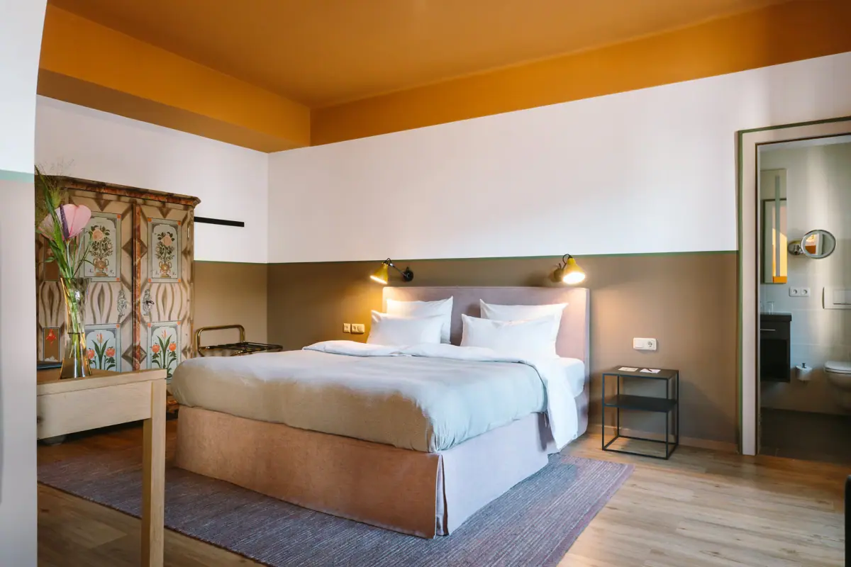 A bed in a hotel room with a stylish interior design.