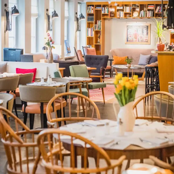 Tables, chairs and a cosy lounge area in the background