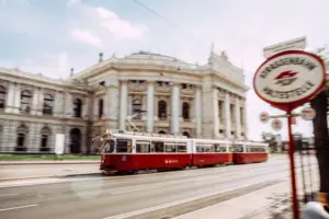 A red and white tram carriage on a road.