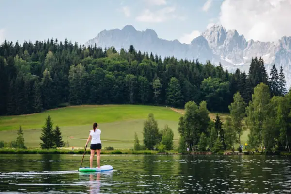 Kitzbühel Schwarzsee A woman on a paddleboard on Schwarzsee lake near Kitzbühel.
