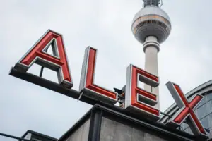 A sign with a tall tower in the background.