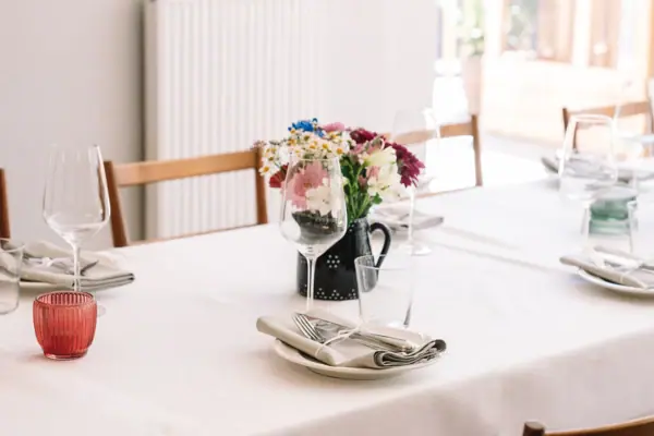 A table with a flower arrangement and glasses on it.
