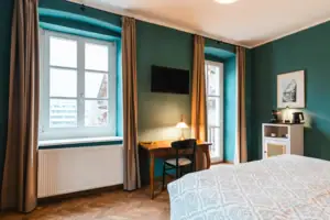 A room with a bed and a desk.