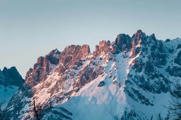 A snow-covered mountain beneath a blue sky.