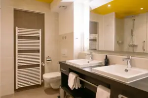 Bathroom with a yellow ceiling, washbasin and taps.