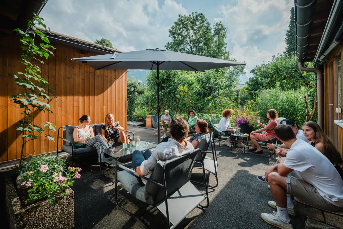 Workation in Garmisch-Partenkirchen A group of people are sitting outside on a terrace.