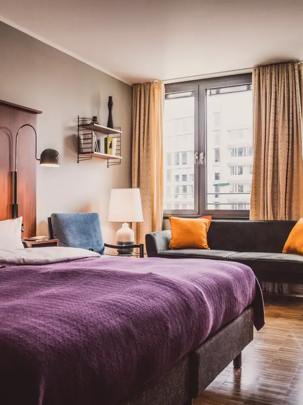 Bedroom with purple bed and couch.