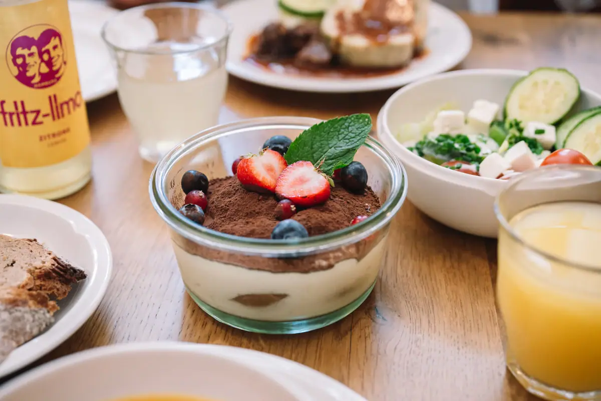 Bowl with dessert, garnished with strawberries and blueberries.