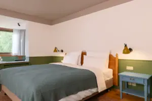A bed with a pillow and a lamp on a bedside table.