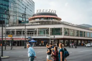 The striking rotunda of Café Kranzler on Berlin’s Kurfürstendamm, with passers-by in the foreground and the modern architecture of City-West.