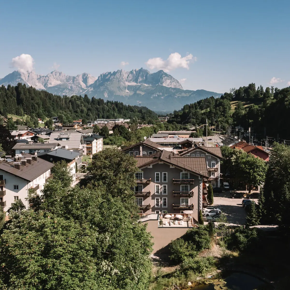 Small town with trees and mountains in the background.