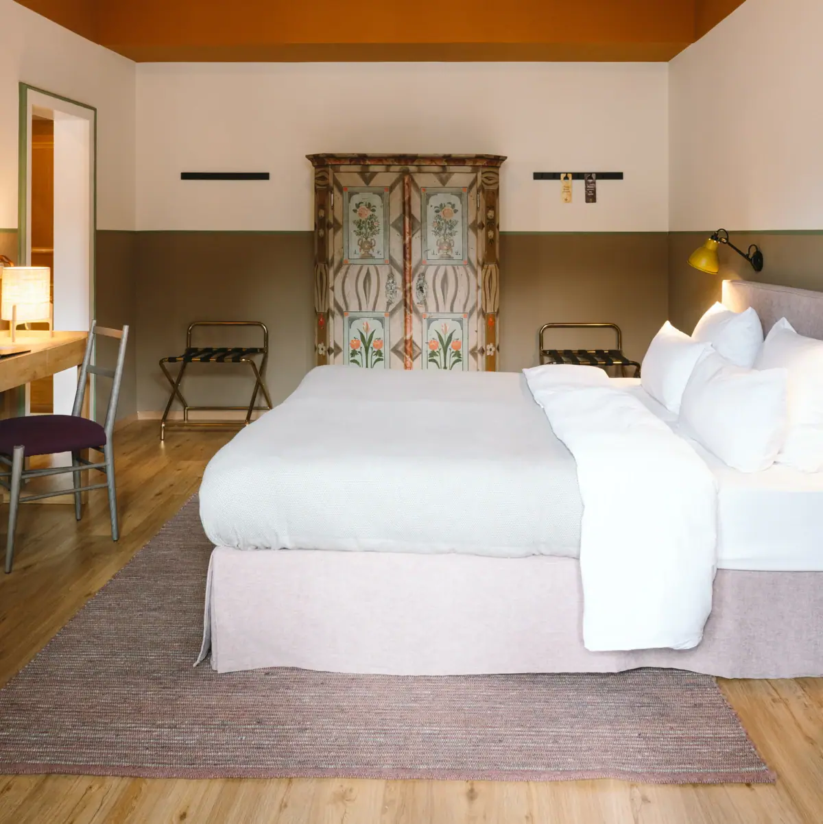 A beautiful hotel room at the HENRI Garmisch-Partenkirchen with a bed and a desk.