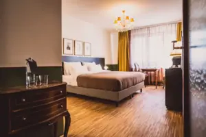 A bedroom with a bed and a chest of drawers.