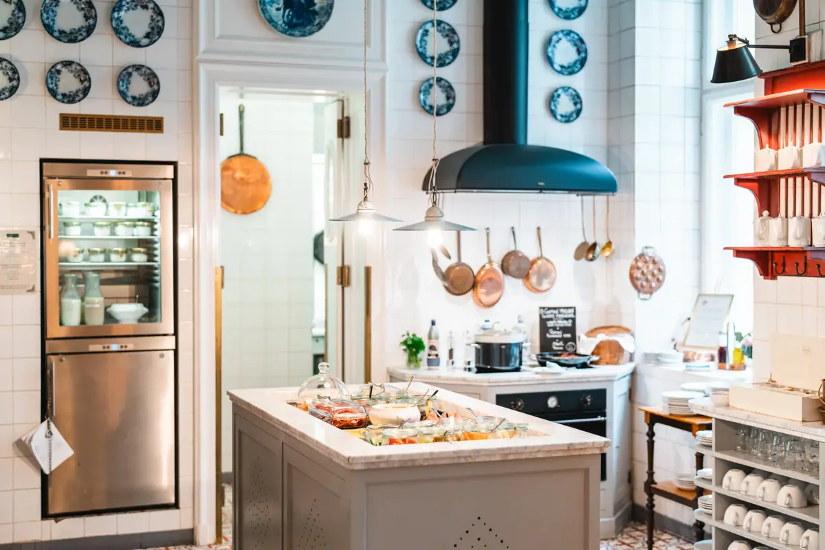 A kitchen with a large island on which food is placed.