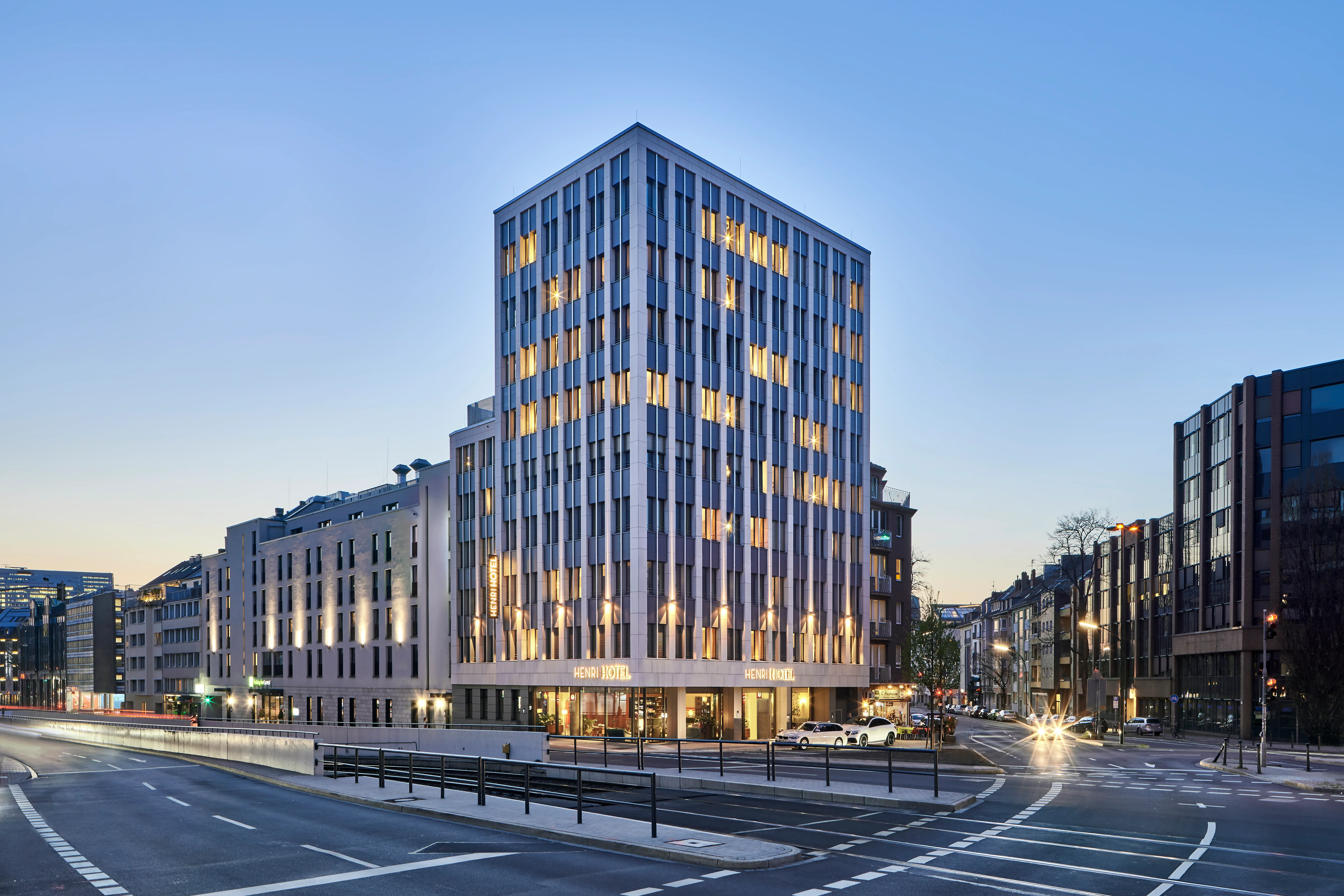 An illuminated tower block in an urban environment at night.