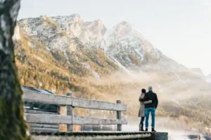 Kitzbühel Alps A man and a woman are standing on a jetty overlooking a mountain range.