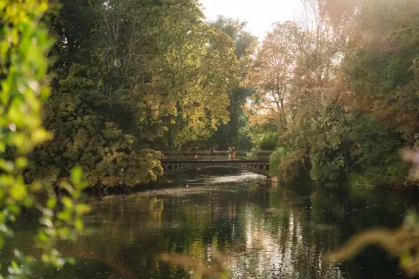 Bridge over a body of water with trees in autumn.