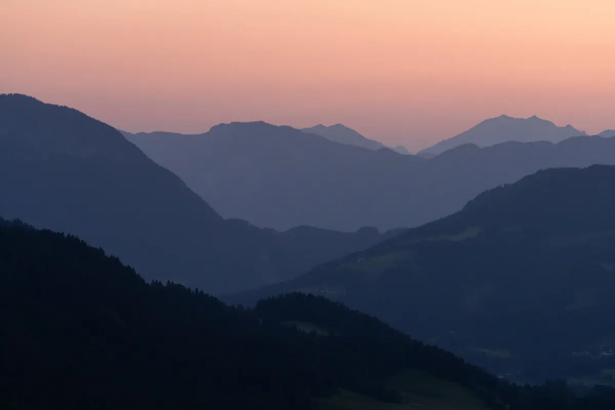 Mountain range with trees and pink sky