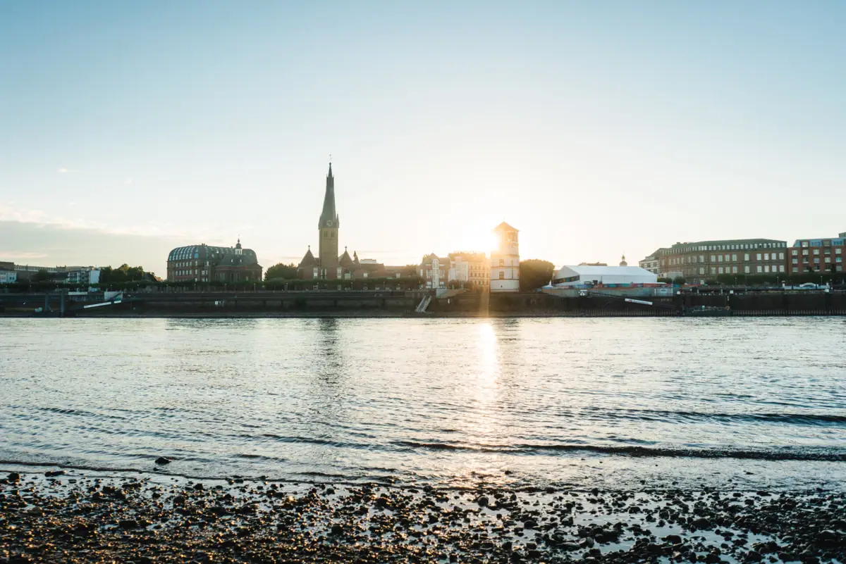 A body of water with buildings and a tower in the background.