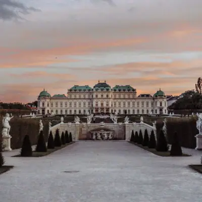 A large white building with statues in front of it.