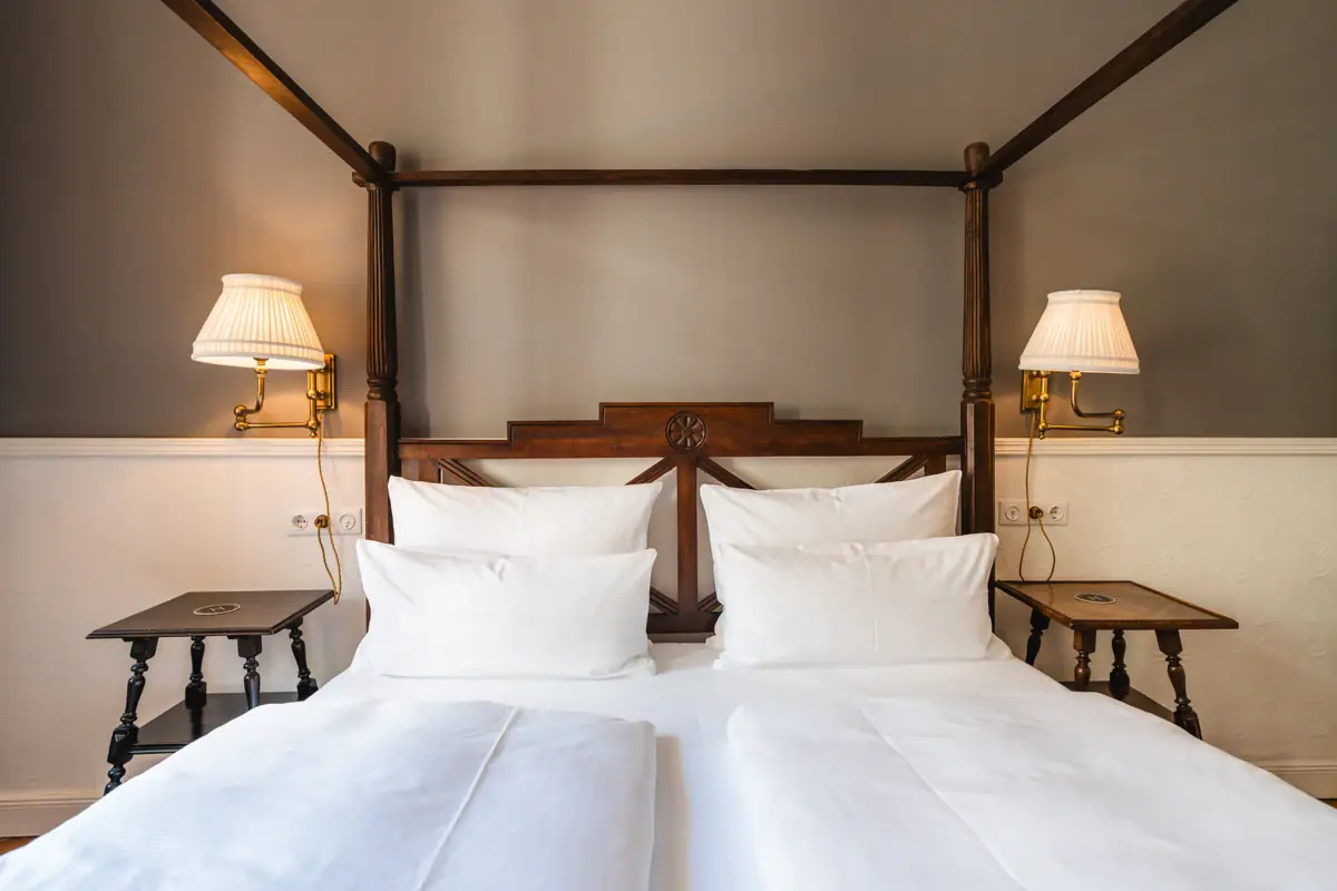 Bed with white sheets and lamps