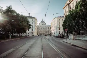 Train tracks in a city with buildings and trees nearby.