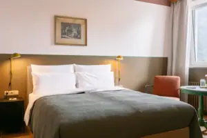 A bed with a pillow and a lamp in a room.