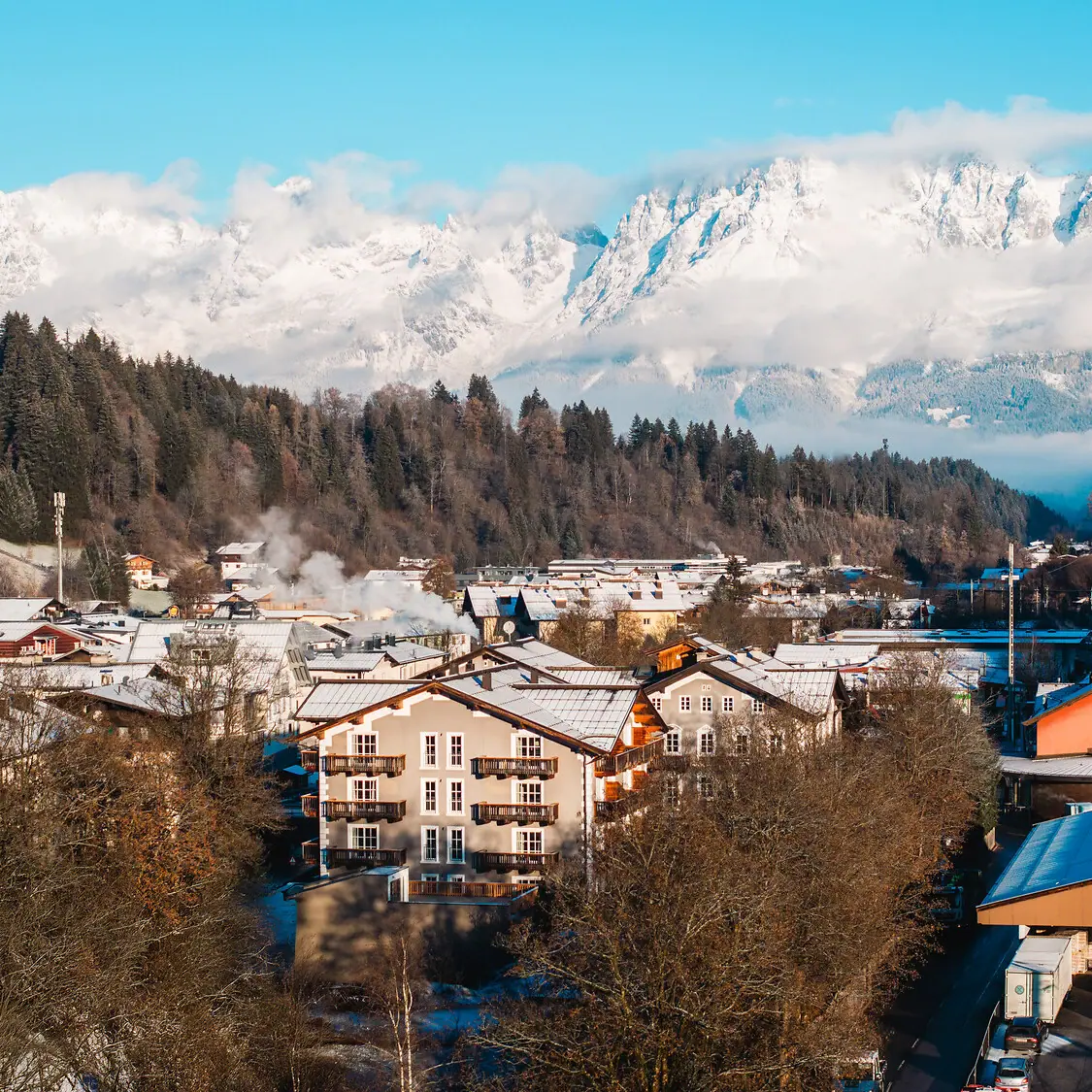Mountain village with snow-capped mountains in the background.