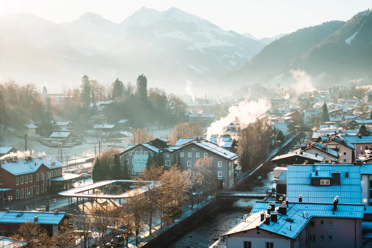 Winter landscape with snow-covered roofs and mountains in the background