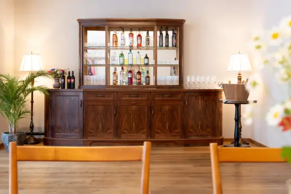 A house bar with glasses and bottles on top.