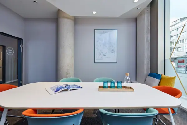 A table with blue chairs and a book on it.