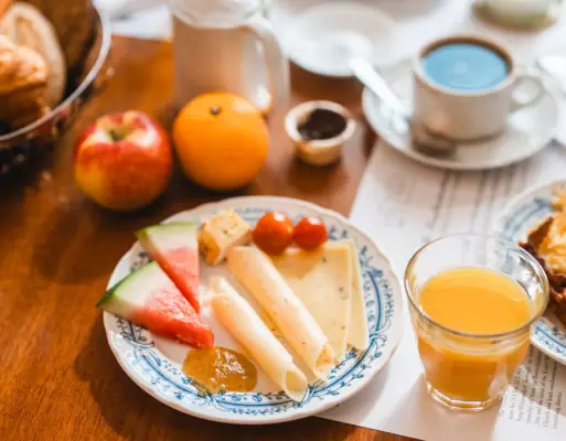 A breakfast plate with cheese and watermelon on a table.