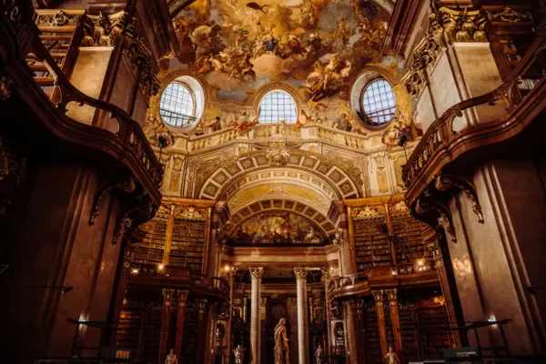 A large, ornate library with a ceiling fresco.