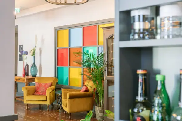 A room with a chandelier and chairs.