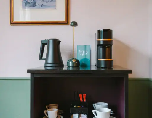 A room bar in a hotel room at the HENRI Hotel in Garmisch-Partenkirchen with a coffee and tea station.