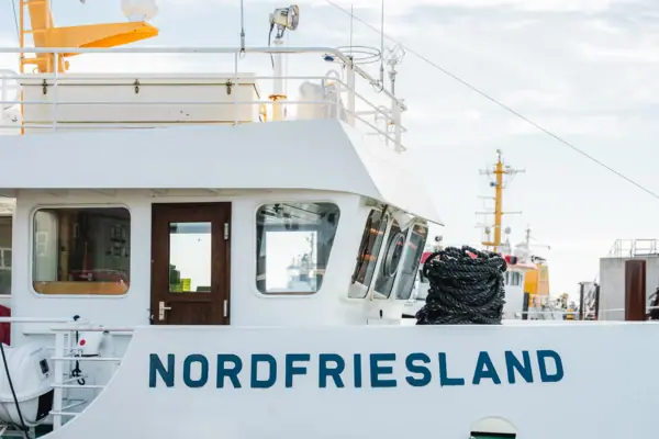 A North Frisian ferry in Cuxhaven with a rope attached to its side.