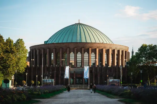 A building with a dome and people walking in front of it.