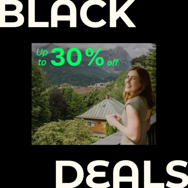 HENRI Black Deals A woman standing on a balcony with trees and mountains in the background.