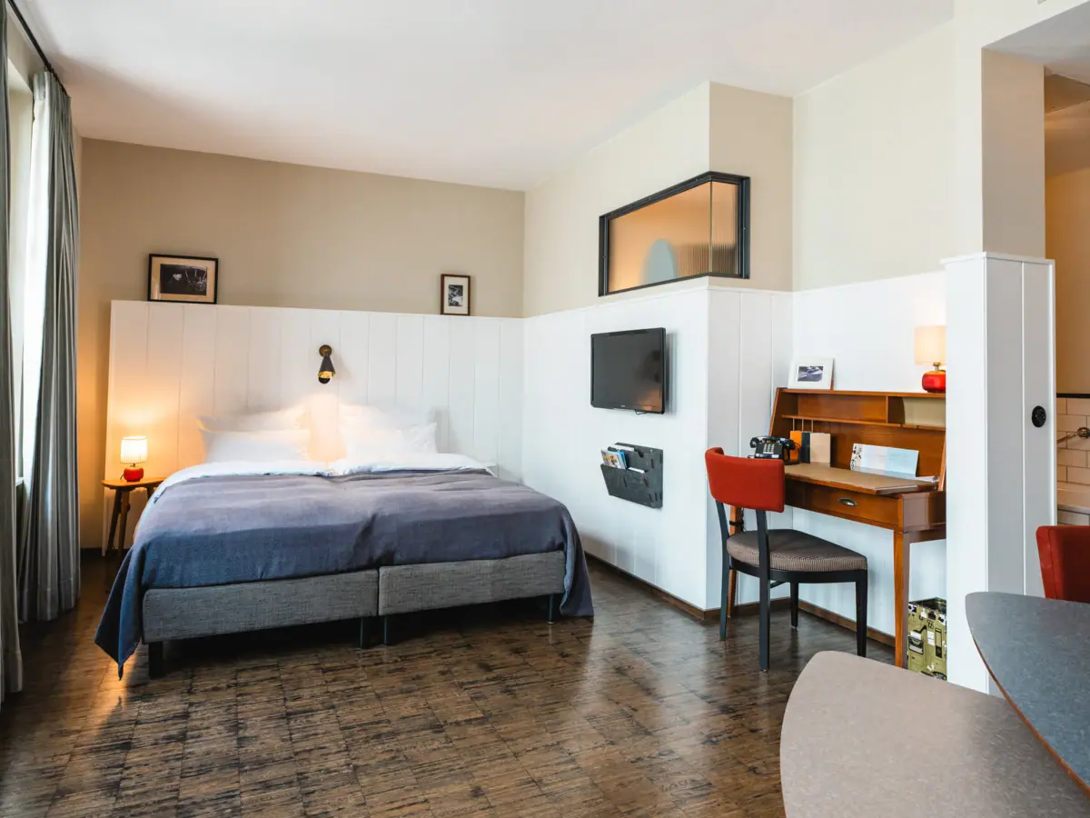 A room with a bed and a desk.