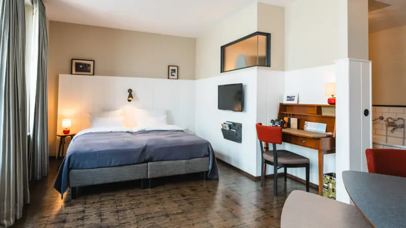 Room with bed and desk at the HENRI Hotel Hamburg.