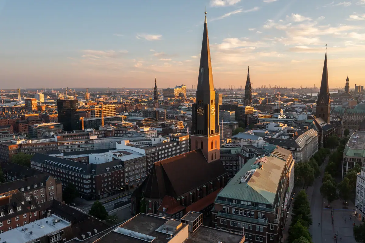 City view with high church tower and slightly cloudy sky.