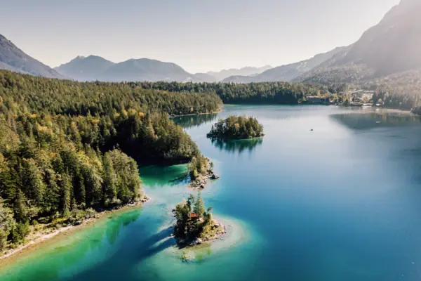 Lake with clear blue water and green fir trees 