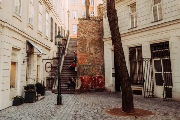 A group of people walk down a flight of stairs in an inner courtyard.