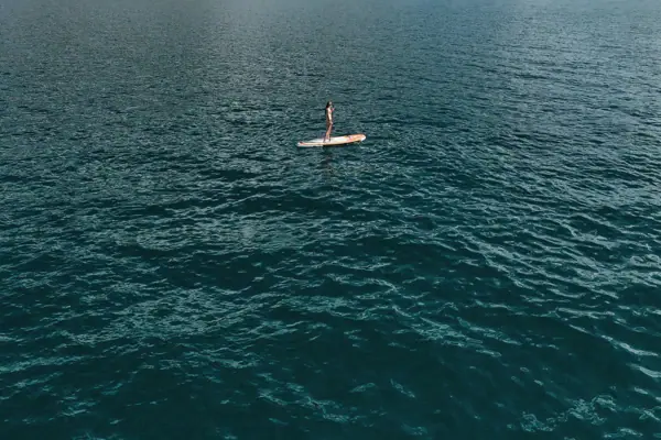 A person on a paddleboard on a lake.