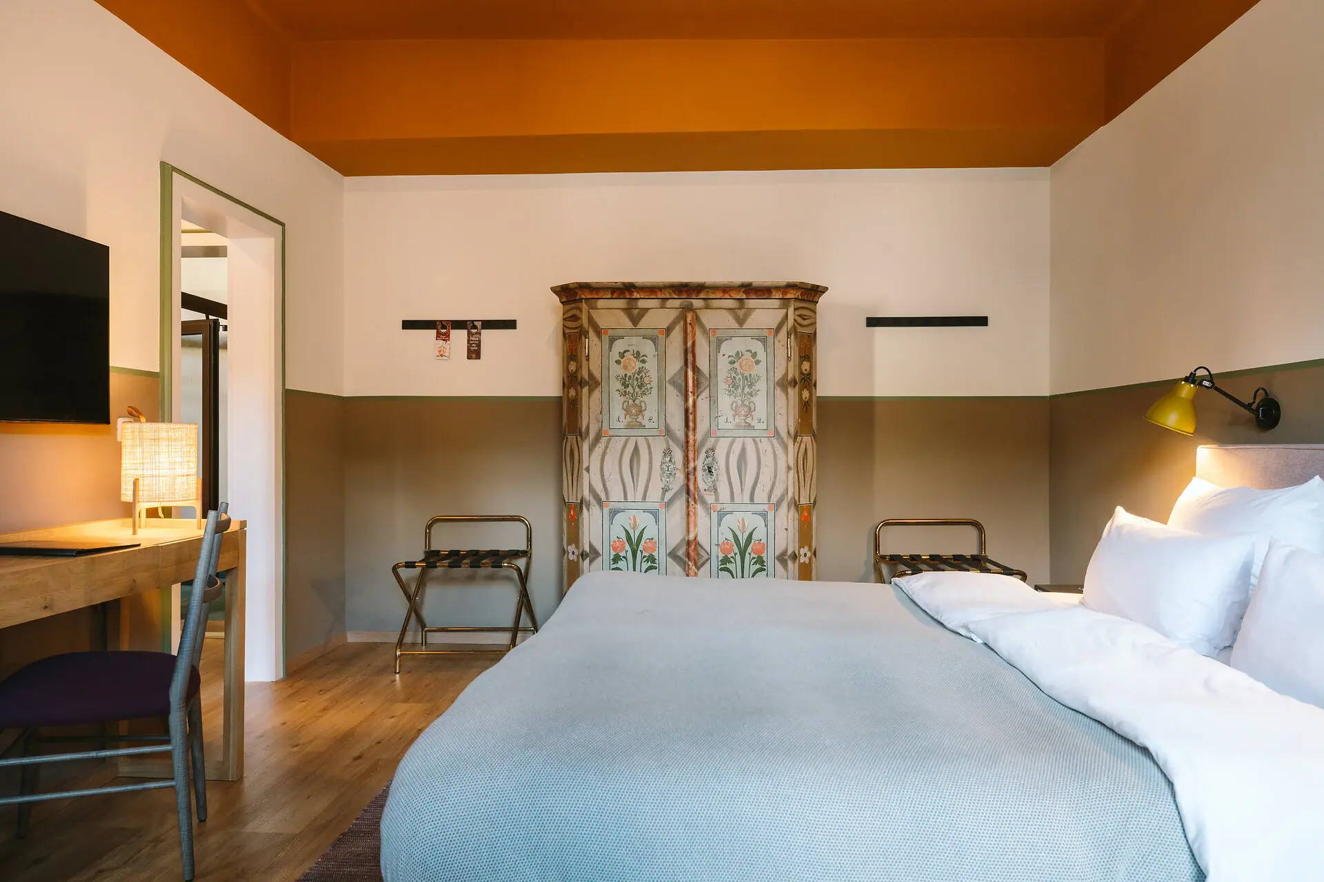 A bed in a hotel room at the HENRI Hotel Garmisch-Partenkirchen with a stylish interior.