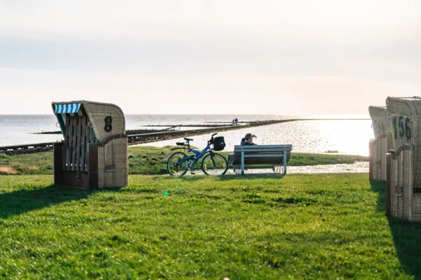 A bicycle on a bench by the water's edge