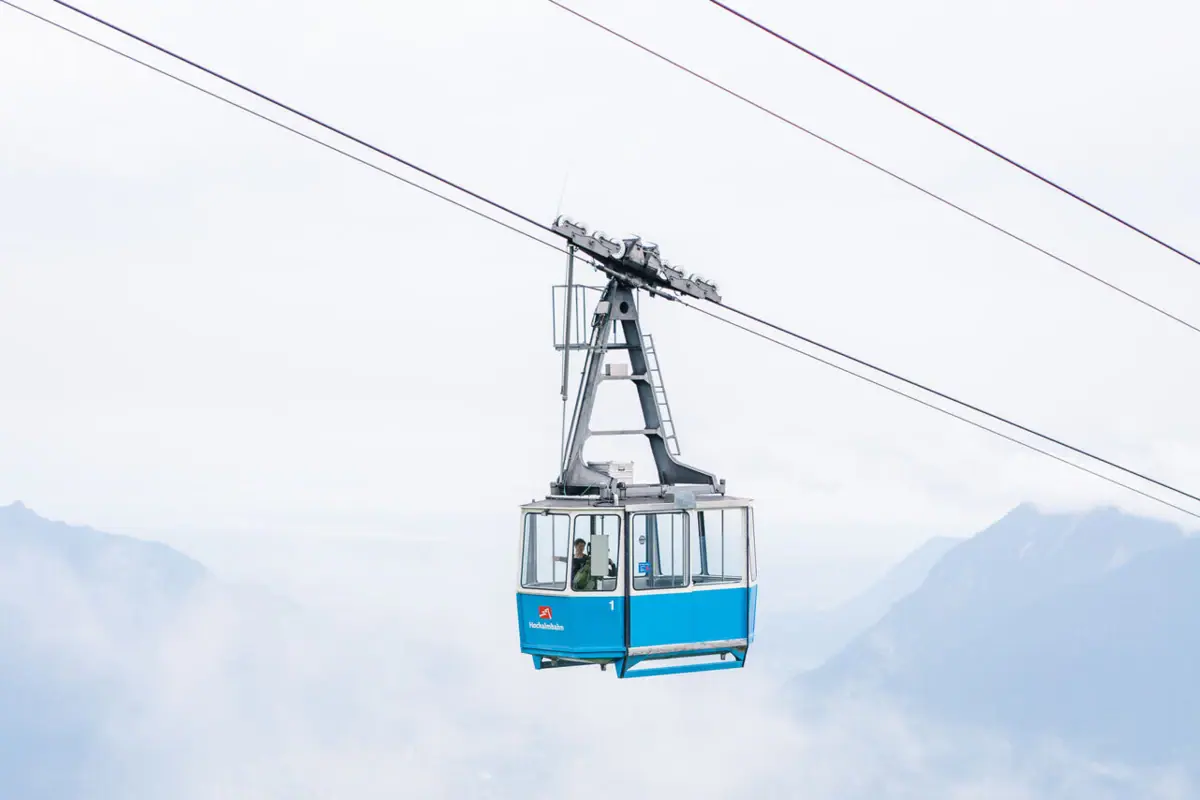 A blue cable car over a mountain.
